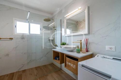 a white bathroom with a sink and a shower at Marina Palace duplex in Adeje