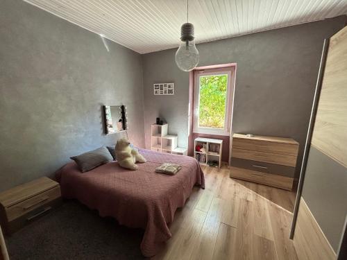 a bedroom with a teddy bear sitting on a bed at MAS PROVENCAL A FLANC DE COLLINE in Bollène