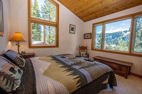 Un dormitorio con una cama en una habitación con ventanas. en KT22 View By Hauserman Rentals, en Olympic Valley