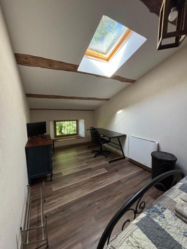 a attic room with a skylight and a desk and a bed at MAS PROVENCAL A FLANC DE COLLINE in Bollène