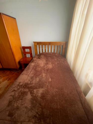 a bed sitting in a room with a curtain at Casa de Liz in Sucre