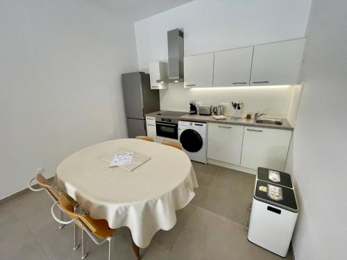 une petite cuisine avec une table et une table et des chaises dans l'établissement Havre de paix neuf et éco-responsable à Golfe-Juan, au Golfe-Juan