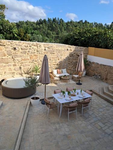 a patio with a table and chairs and umbrellas at Ninho das Andorinhas in Monção