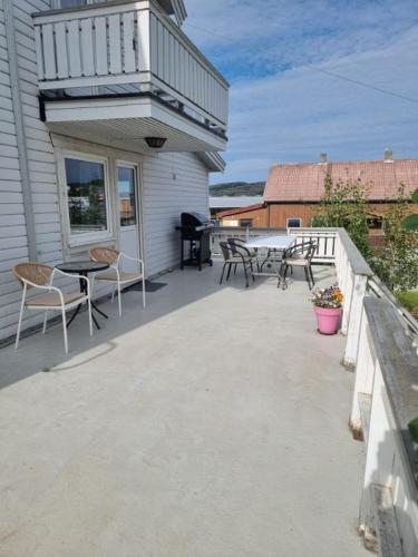 a patio with tables and chairs on a house at Koselig Feriehus ved Kirkenes sentrum in Kirkenes