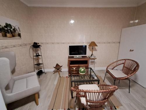 a living room with a tv and a couch and a chair at Ninho das Andorinhas in Monção