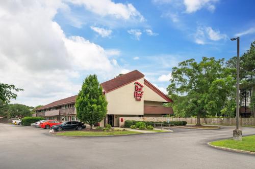 a building with cars parked in a parking lot at Red Roof Inn Virginia Beach in Virginia Beach