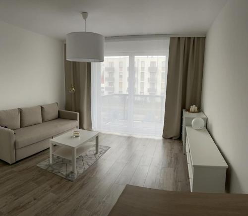 a living room with a couch and a table at Kawalerka Cukrowa in Szczecin