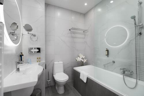 a white bathroom with a sink and a toilet at CHLOE Hotel Budapest in Budapest