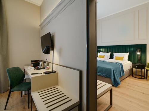 a hotel room with a bed and a desk and a room at CHLOE Hotel Budapest in Budapest