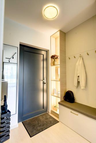a room with a door and a shelf with towels at By The Lakeside Apartment in Balatonlelle