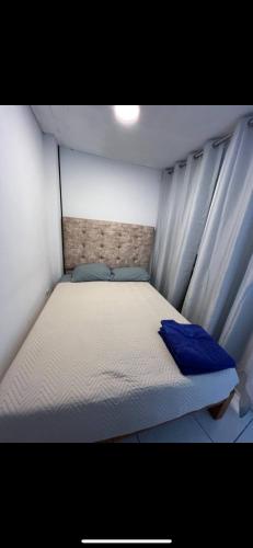 - un petit lit avec des oreillers bleus dans l'établissement Pequeño Departamento, à Los Blancos