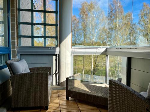 a screened in porch with two chairs and a glass table at Peaceful Seaside Home - Sauna, Balcony, Wi-Fi in Helsinki
