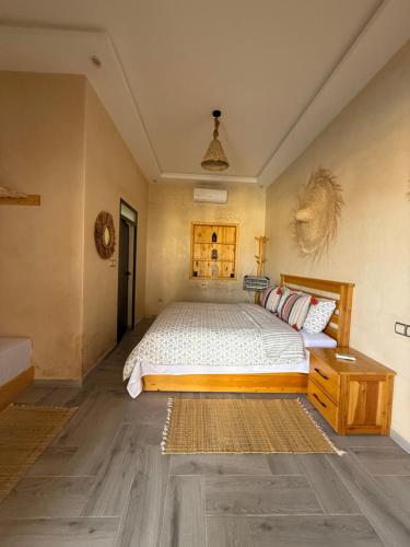 a bedroom with a large bed and a wooden table at Kaouki Dream House in Sidi Kaouki