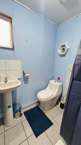 a blue bathroom with a toilet and a sink at Minidepto temuco in Temuco