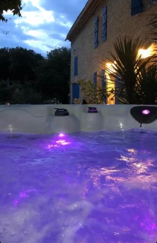 a pool with purple lights in front of a house at MAS PROVENCAL A FLANC DE COLLINE in Bollène