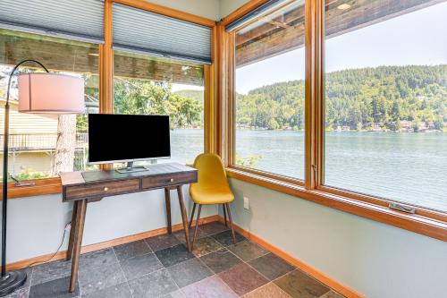 a desk with a computer and a yellow chair in a room with windows at Modern Summit Lake Escape - Spacious Deck with View! in Kamilche