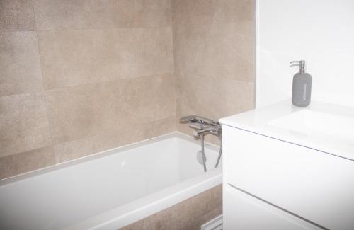 a bathroom with a white tub and a sink at Apartament Alvor in Albur Village Lote A in Alvor