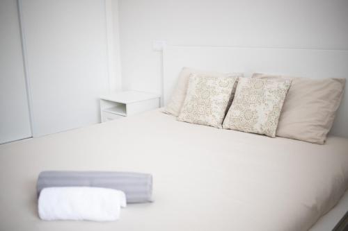a white bed with two pillows on top of it at Apartament Alvor in Albur Village Lote A in Alvor