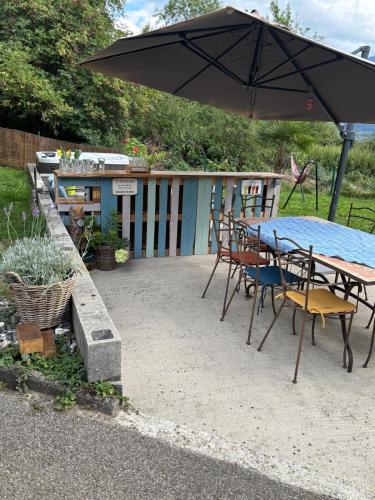 a patio with an umbrella and a table and chairs at gite de la chouette in Thyez