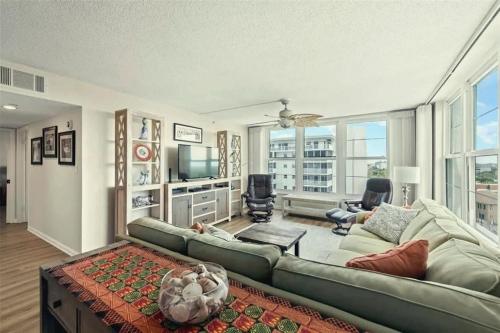 a living room with a green couch and a television at Charming Two-Bedroom Gulf-Front Condo in Venice