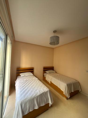 a bedroom with two beds and a window at Appartement à Tanger in Tangier