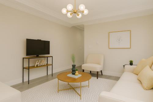 un soggiorno con un divano bianco e una TV di Spacious 4BD Home in Vancouver a Vancouver