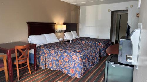 a hotel room with two beds and a desk at Rodeway Inn Dunmore in Dunmore