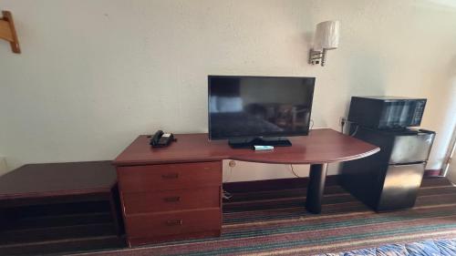a desk with a television on top of it in a room at Rodeway Inn Dunmore in Dunmore