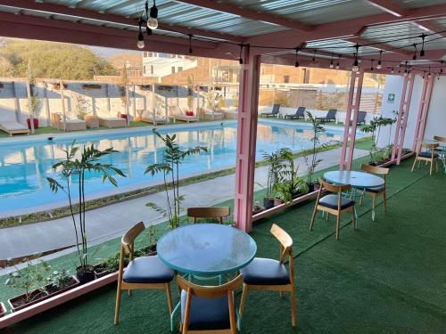 a balcony with tables and chairs and a swimming pool at Hotel Balistra in Ica