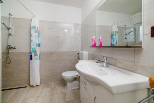 Un baño con lavabo, inodoro y ducha. en Apartments Petar, en Kampor