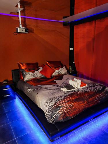 a bed in a room with blue lights at L'Escale du Donon - Chambre Noire in Grandfontaine