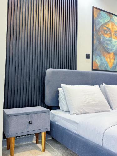 a bedroom with a bed and a table and a painting at The Nook - Super Luxurious 1 Bedroom in Wuse 2 in Abuja