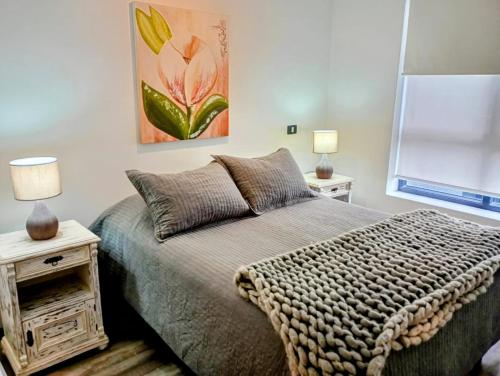 a bedroom with a bed and a painting on the wall at Hogar Nomada in Puerto Varas