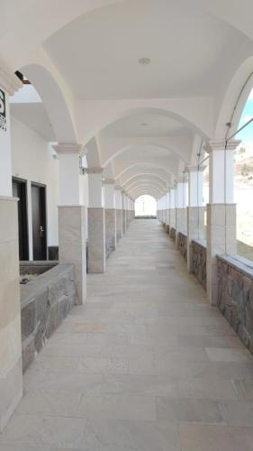 an empty hallway of a building with white columns at Xima Colca in Yanque