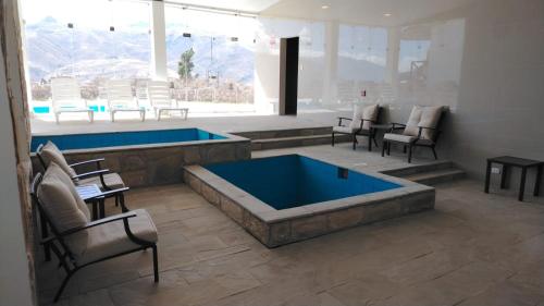a large swimming pool with chairs and a table and a tablektop at Xima Colca in Yanque