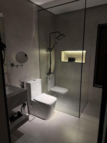 a bathroom with a shower and a toilet and a sink at Marvin Suites in Al Wajh