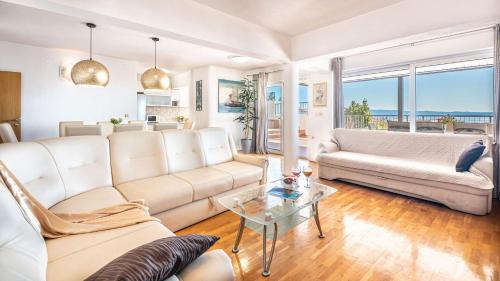 ein Wohnzimmer mit Sofa und Tisch in der Unterkunft Apartments Sinovcic with terrace & sea view, 4 min walk to the beach in Podstrana