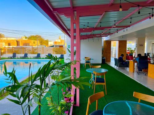 an office with a pool and tables and chairs at Hotel Balistra in Ica