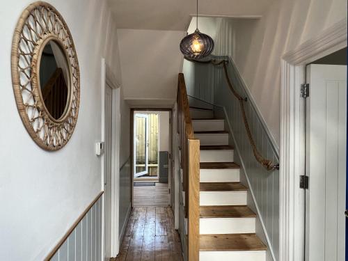 a hallway with stairs and a mirror on the wall at Still Waters in Brixham
