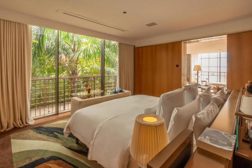 a bedroom with a large bed and a large window at Rosewood São Paulo in Sao Paulo