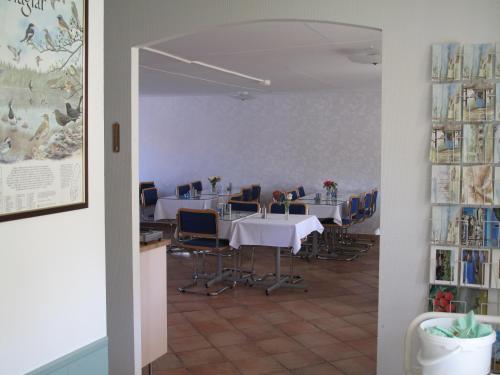 a dining room with tables and chairs in a room at Hotell Turistgården i Simrishamn in Simrishamn
