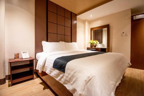 a bedroom with a large bed with a large headboard at ECL Resort Hotel Boracay in Boracay