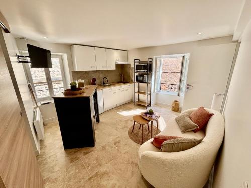 ein Wohnzimmer mit Sofa und eine Küche in der Unterkunft Chaleureux T1 avec Balcon in Vals-les-Bains