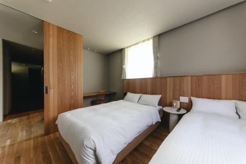 a bedroom with two beds and a window at 山郷 Villas in Nature in Otaru