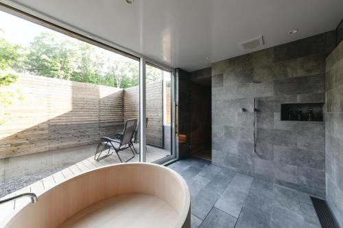 a bathroom with a large window and a tub at 山郷 Villas in Nature in Otaru