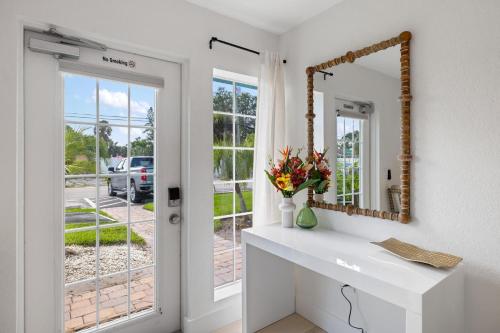 a white bathroom with a mirror and a sink at Heat of Siesta Village Walk to Beach w heated Pool in Siesta Key