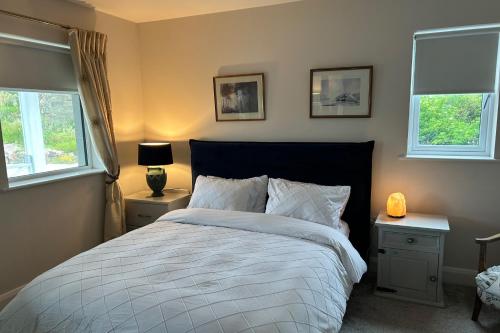 a bedroom with a bed and two windows at Luxury Galway Getaway with 5 Bedrooms in Galway