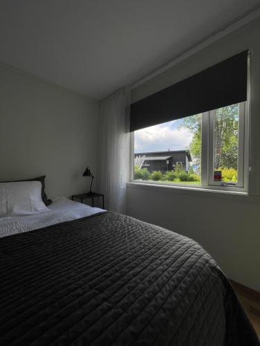 a bedroom with a bed and a large window at Lys og koselig leilighet nært flyplass og tur terreng in Tromsø