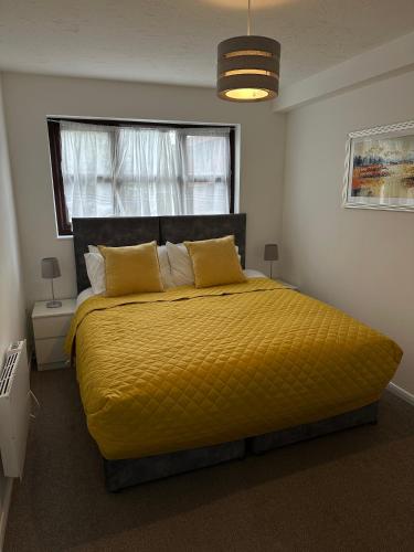 a bedroom with a large yellow bed with a window at Exquisite 2Bed Near Transport Link & Bluewater Mall in Stonewood