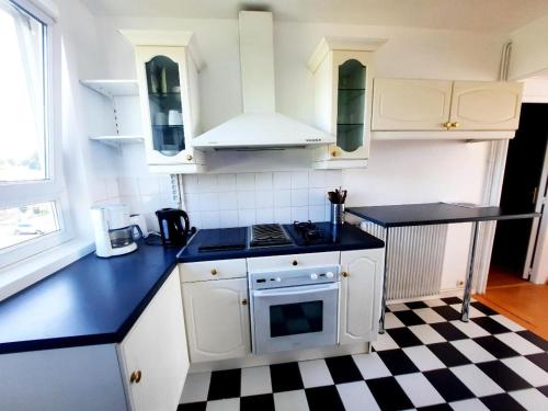 a kitchen with a black and white checkered floor at Chez Simon et Loreline Yerres proche Paris Orly Disney in Yerres